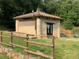 um pequeno edifício de pedra com uma cerca em frente em Agriturismo I Sassi Grossi em Corciano