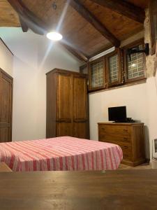 um quarto com uma cama e uma secretária com uma televisão em Agriturismo I Sassi Grossi em Corciano