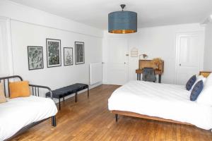 a white room with two beds and a table at La Demeure de Chemonton - 6 personnes, 2 chambres in Blois
