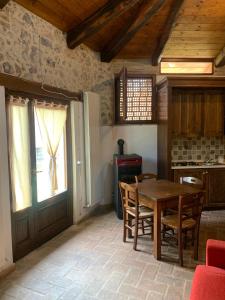 eine Küche mit einem Tisch und Stühlen sowie einem Fenster in der Unterkunft Agriturismo I Sassi Grossi in Corciano