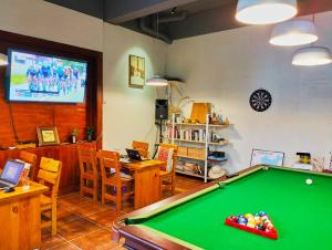 a living room with a pool table and a tv at YangShuo Eden Inn in Yangshuo
