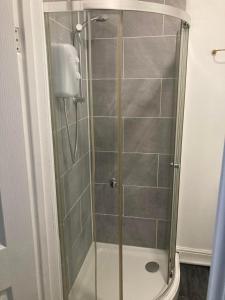 a shower with a glass door in a bathroom at The New Astoria Hotel in Blackpool