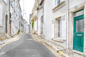 an empty street in an old city with green doors at La Demeure de Chemonton - 6 personnes, 2 chambres in Blois