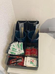 a shelf with three cups and toothbrushes and toothpaste at The New Astoria Hotel in Blackpool
