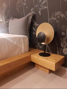 a lamp on a wooden table next to a bed at Sroom Apartment in Missolonghi
