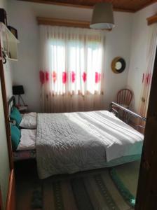 Schlafzimmer mit einem Bett und einem Fenster in der Unterkunft Τα πλατάνια 