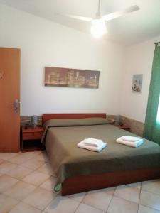 1 dormitorio con 1 cama con 2 toallas en B&B Bella Calasetta, en Calasetta