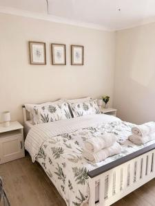 a bedroom with a white bed with towels on it at Relaxing retreat near Norfolk Broads in Norwich
