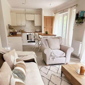 a living room with two couches and a kitchen at Relaxing retreat near Norfolk Broads in Norwich