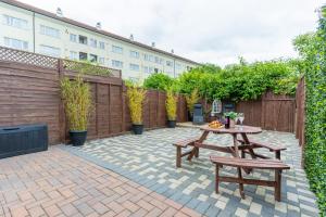 a patio with a table and chairs and a fence at Stylish One Bed House with Private Garden and Free Parking in Northolt
