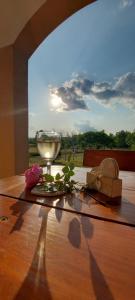 a glass of wine on a wooden table with a view at Holiday house and apartments Vale in Duga Resa