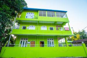 a green building with white doors and windows at JUNGLE STAR MANSION in Kāziranga