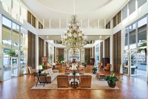 a large lobby with a chandelier and tables and chairs at The Kahala Hotel and Resort in Honolulu