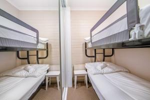 two bunk beds in a room with two chairs at Snow Ski Apartments 35 in Falls Creek