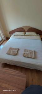 uma grande cama branca com duas almofadas em КЪЩА ЗА ГОСТИ ВОДЕНИЦАТА em Devin