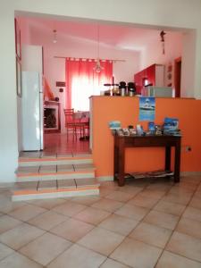 カラゼッタにあるB&B Bella Calasettaのオレンジの壁のキッチン、テーブルが備わります。