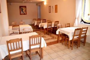 jadalnia z białymi stołami i drewnianymi krzesłami w obiekcie Fazolandia w Zwardoniu