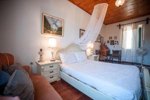 Giannádes的住宿－Maria's Vintage House，卧室配有白色的床和沙发