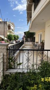 einen Balkon eines Hauses mit einem schmiedeeisernen Zaun in der Unterkunft Mairi’s Apartment in Nea Artaki