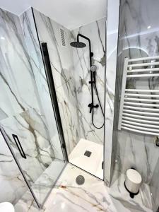 een badkamer met een douche met een glazen deur bij Apartamento Olívico con Parking in Vigo