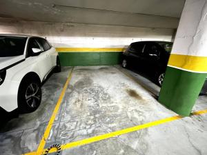 twee auto's staan geparkeerd in een parkeergarage bij Apartamento Olívico con Parking in Vigo