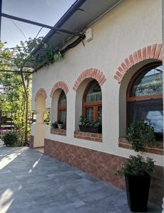 a building with three windows with potted plants on it at Miri's House in Eforie Sud