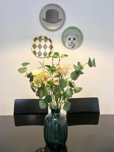 een vaas met bloemen erin op een tafel bij Apartamento Olívico con Parking in Vigo