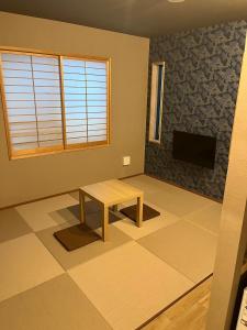 uma sala de estar com uma mesa e uma televisão em Asagaya House em Tóquio