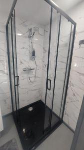 a bathroom with a shower with white marble walls at Pids randõ in Kolka