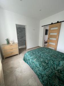 a bedroom with a bed and a dresser and a closet at LE JEAN JAURÈS Arrivée Autonome in Vierzon