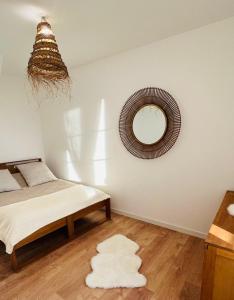 Schlafzimmer mit einem Bett und einem Wandspiegel in der Unterkunft LE JEAN JAURÈS Arrivée Autonome in Vierzon