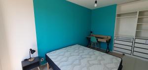 a blue bedroom with a bed and a desk at Résidence Salamandre - Maison Bois Cosy Calme avec parking pour 4 à 10 pers idéal couples et familles à 500m de la plage à Saint-Marc-sur-mer in Saint-Nazaire