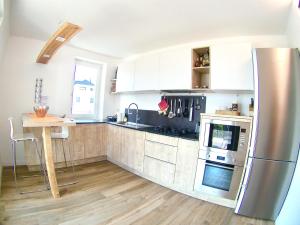 a kitchen with a stainless steel refrigerator and a table at B&B - Apartments Sunnwies in Marlengo