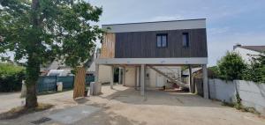 een huis met een zwart-witte gevel bij Résidence Salamandre - Maison Bois Cosy Calme avec parking pour 4 à 10 pers idéal couples et familles à 500m de la plage à Saint-Marc-sur-mer in Saint-Nazaire