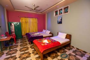 een slaapkamer met 2 bedden, een tafel en een plafond bij JUNGLE STAR MANSION in Kāziranga