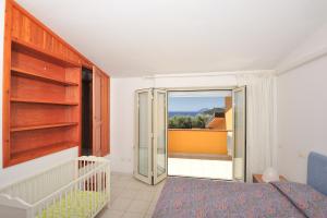 アルバタックスにあるArbatax Le Terrazze sul Mareのベッドルーム1室(ベッド1台付)、スライド式ガラスドアが備わります。