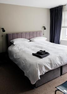 a bed with a black robe on top of it at Suburban Hideaway in Suffolk in Ipswich