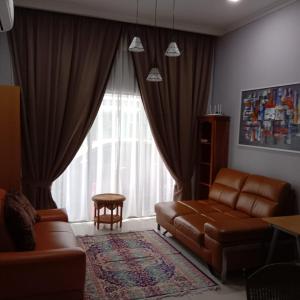 a living room with a couch and a chair and a window at Sarod Inn Meru Homestay 3-bedroom Apartment in Klang