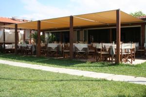 a restaurant with tables and chairs under a pavilion at Hotel La Pigna in Marina di Pietrasanta