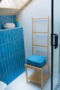 un baño con una silla y una pared de azulejos azules en Sominy House dom na Kaszubach, en Sominy