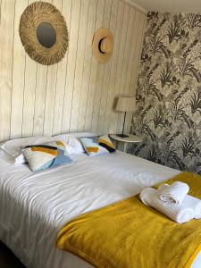 a bedroom with a bed with towels on it at Hôtel Le Grain de Sable in Arès