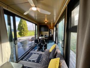 uma sala de estar num trailer com um sofá e janelas em Waitomo Retreat em Hangatiki