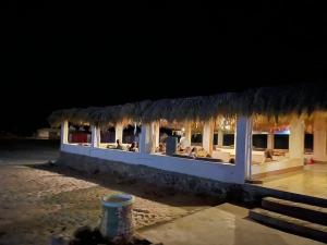 a building with a restaurant with a thatched roof at Al Khalil Beach Camp in Nuweiba