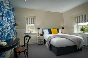 1 dormitorio con cama y escritorio con almohada amarilla en Monks Ballyvaughan, en Ballyvaughan