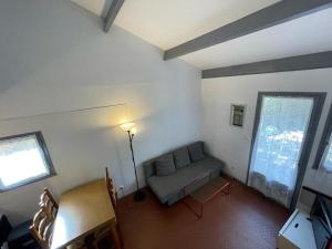 a living room with a couch and two windows at Maison Capbreton, 2 pièces, 4 personnes - FR-1-413-100 in Capbreton