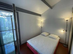 a bedroom with a bed with two lamps and a window at Maison Capbreton, 2 pièces, 4 personnes - FR-1-413-100 in Capbreton