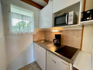 a small kitchen with a sink and a microwave at Maison proche plage avec jardinet, 3 pièces, 40m², parking privé, animaux acceptés - FR-1-478-131 in Saint-Pierre-Quiberon