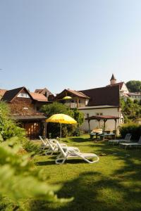 2 chaises de jardin et un parasol dans l'herbe dans l'établissement Apartment-Haus Gundelfinger, à Gräfenberg