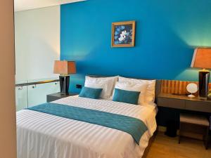 a blue bedroom with a bed with a blue wall at Paradis Homestay Marina Ha Long in Ha Long