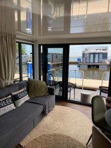 a living room with a couch and a large window at SeaYou House boat in Offingawier